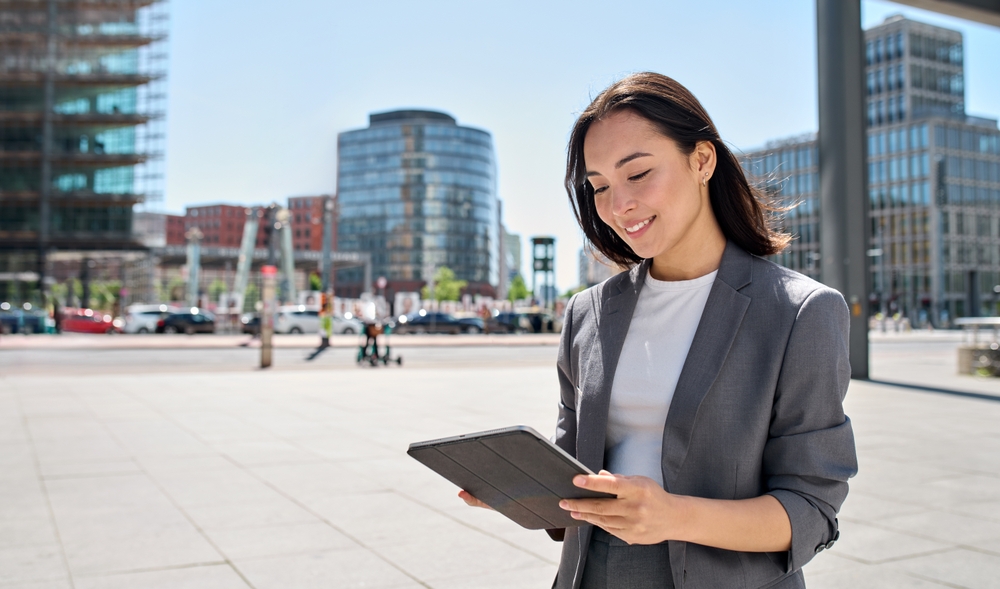 Woman looking at her iPad in the middle of a city